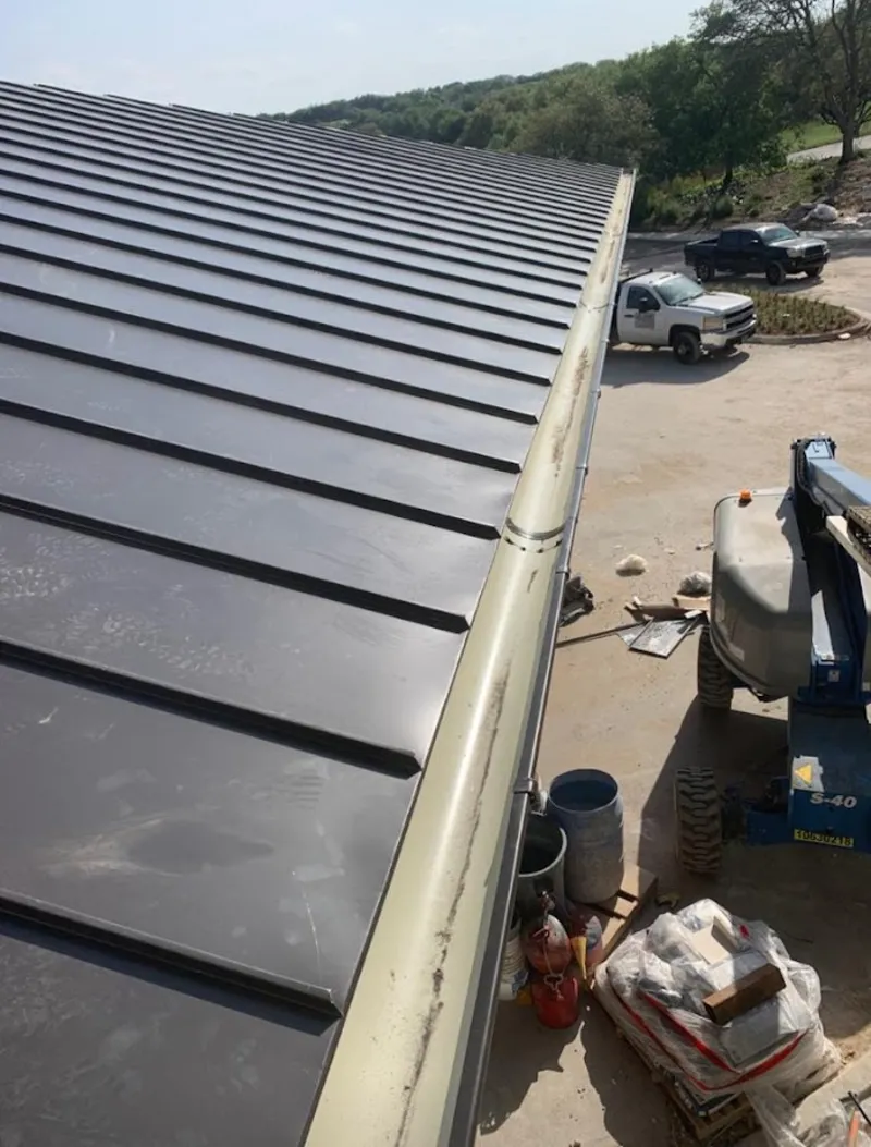 Standing seam panel and gutter detail on a metal roofing jobsite in Coalinga